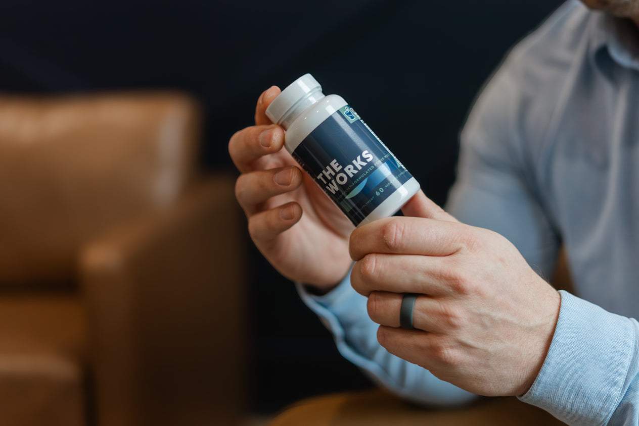Pharmacist holding a bottle of THE WORKS multivitamin