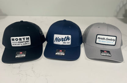 Three baseball caps in black, navy, and gray with 'North Century' branding on a white background.