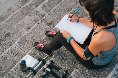 woman working out writes down goals